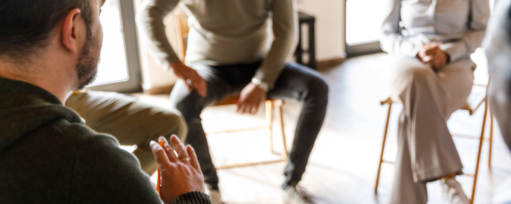 Male Therapist Explaining The Concept Of The Group Therapy Session To Its Participants